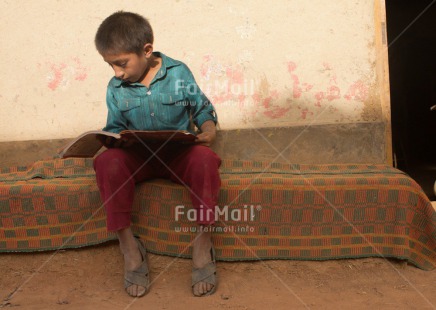 Fair Trade Photo 5 -10 years, Activity, Book, Colour image, Dailylife, Day, Education, Ethnic-folklore, Latin, One boy, Outdoor, People, Peru, Reading, Rural, Sitting, South America, Street