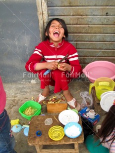 Fair Trade Photo 5-10 years, Activity, Casual clothing, Clothing, Cooking, Dailylife, Latin, One girl, People, Peru, Red, Sitting, Smiling, South America, Streetlife, Vertical, Working