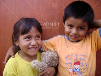 Fair Trade Photo Activity, Brother, Care, Casual clothing, Clothing, Colour image, Cute, Day, Family, Horizontal, Looking at camera, One boy, One girl, Outdoor, People, Peru, Portrait halfbody, Sister, Smiling, South America, Teddybear, Together, Two children, Warmth