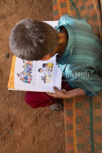 Fair Trade Photo 5 -10 years, Activity, Book, Colour image, Dailylife, Day, Education, Latin, One boy, Outdoor, People, Peru, Reading, Rural, Sitting, South America, Street