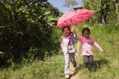 Fair Trade Photo Activity, Casual clothing, Clothing, Colour image, Day, Emotions, Friendship, Happiness, Horizontal, Outdoor, People, Peru, Running, Rural, Smiling, South America, Together, Two girls, Umbrella, Walking