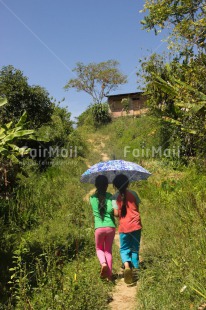 Fair Trade Photo Activity, Casual clothing, Clothing, Colour image, Day, Emotions, Friendship, Happiness, Outdoor, People, Peru, Running, Rural, Smiling, South America, Together, Two girls, Umbrella, Vertical, Walking