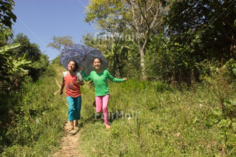 Fair Trade Photo Activity, Casual clothing, Clothing, Colour image, Day, Emotions, Friendship, Happiness, Horizontal, Outdoor, People, Peru, Running, Rural, Smiling, South America, Together, Two girls, Umbrella, Walking