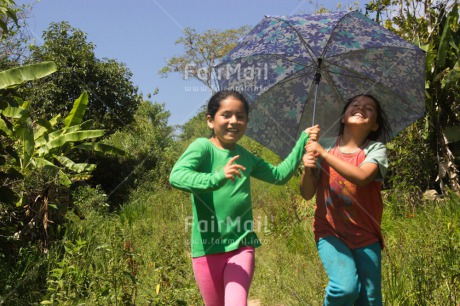 Fair Trade Photo Activity, Casual clothing, Clothing, Colour image, Day, Emotions, Friendship, Happiness, Horizontal, Outdoor, People, Peru, Running, Rural, Smiling, South America, Together, Two girls, Umbrella, Walking