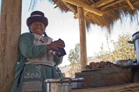Fair Trade Photo Activity, Clothing, Colour image, Cooking, Ethnic-folklore, Fair trade, Food and alimentation, Horizontal, Latin, Looking at camera, One woman, Pachamanca, People, Peru, Smiling, South America, Traditional clothing
