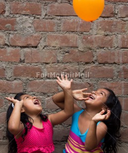 Fair Trade Photo Activity, Balloon, Colour image, Cooperation, Emotions, Friendship, Happiness, People, Peru, Playing, Smiling, South America, Throwing, Twin, Two girls, Vertical