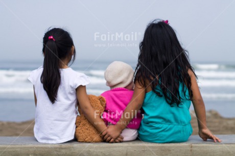 Fair Trade Photo 0-5 years, 5 -10 years, Activity, Animals, Beach, Bear, Colour image, Day, Emotions, Friendship, Girl, Girls, Happiness, Horizontal, Ocean, Outdoor, People, Peru, Sea, Sister, Sitting, South America, Teddybear, Three, Water