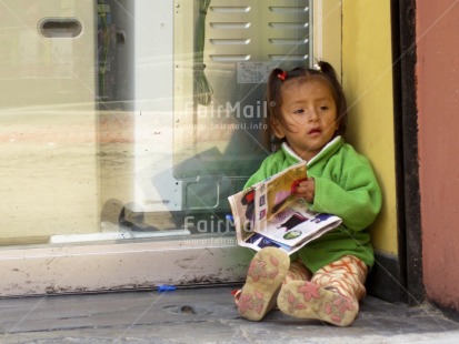Fair Trade Photo 0-5 years, Activity, Colour image, Day, Education, Horizontal, Latin, One girl, Outdoor, People, Peru, Portrait fullbody, Reading, School, Sitting, Social issues, South America, Street, Streetlife