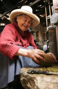 Fair Trade Photo 70-75 years, Activity, Clothing, Colour image, Cooking, Crafts, Day, Ethnic-folklore, Indoor, Latin, Looking away, Old age, One woman, People, Peru, Portrait fullbody, Rural, Sitting, Smiling, South America, Strength, Traditional clothing, Vertical, Working