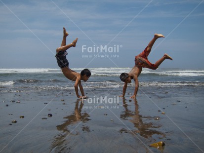 Fair Trade Photo 10-15 years, Activity, Beach, Colour image, Doing handstand, Friendship, Horizontal, Latin, Outdoor, People, Peru, Sand, Sea, South America, Sport, Summer, Together, Two boys, Water, Yoga