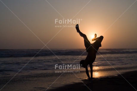 Fair Trade Photo Activity, Backlit, Beach, Colour image, Doing handstand, Emotions, Evening, Happiness, One boy, Outdoor, People, Peru, Playing, Sand, Sea, Silhouette, South America, Summer, Sunset, Yoga