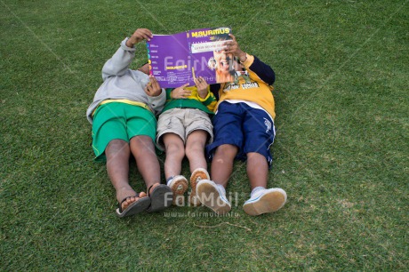 Fair Trade Photo 5 -10 years, Activity, Book, Casual clothing, Clothing, Colour image, Cooperation, Dailylife, Day, Education, Grass, Group of boys, Looking away, Outdoor, People, Peru, Portrait fullbody, Reading, South America, Streetlife, Together