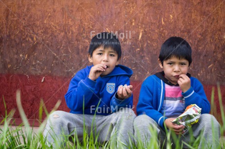 Fair Trade Photo Activity, Colour image, Day, Eating, Food and alimentation, Friendship, Grass, Health, Horizontal, Looking at camera, Outdoor, People, Peru, Portrait halfbody, Rural, South America, Two boys