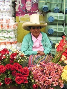 Fair Trade Photo Activity, Clothing, Colour image, Dailylife, Entrepreneurship, Flower, Hat, Looking at camera, Market, One woman, Outdoor, People, Peru, Portrait fullbody, Rural, Saleswoman, Selling, Sombrero, South America, Streetlife, Vertical, Working