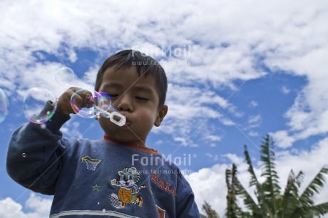 Fair Trade Photo Activity, Casual clothing, Clothing, Clouds, Colour image, Day, Horizontal, Looking away, One boy, Outdoor, People, Peru, Playing, Portrait halfbody, Rural, Seasons, Sky, Soapbubble, South America, Summer, Young