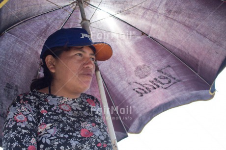 Fair Trade Photo 40-45 years, Activity, Cap, Casual clothing, Clothing, Colour image, Horizontal, Latin, Looking away, Low angle view, One woman, People, Peru, Portrait halfbody, South America, Umbrella