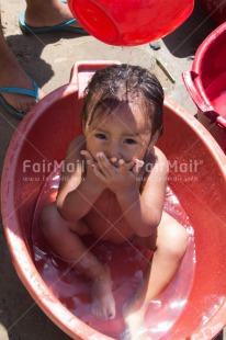 Fair Trade Photo 5 -10 years, Activity, Colour image, Dailylife, Day, Health, Horizontal, Latin, Looking at camera, One girl, Outdoor, People, Peru, Portrait fullbody, Sanitation, Showering, South America, Washing, Water