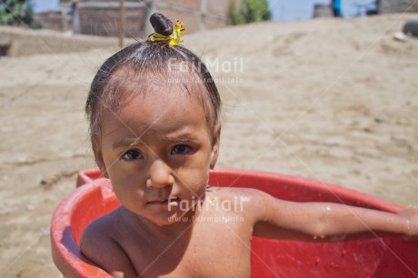 Fair Trade Photo 5 -10 years, Activity, Colour image, Dailylife, Day, Health, Horizontal, Latin, Looking at camera, One girl, Outdoor, People, Peru, Portrait headshot, Sanitation, Showering, South America, Washing, Water