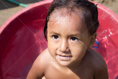 Fair Trade Photo 5 -10 years, Activity, Colour image, Dailylife, Day, Health, Horizontal, Latin, Looking at camera, One girl, Outdoor, People, Peru, Portrait headshot, Sanitation, Showering, South America, Washing, Water