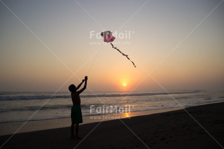 Fair Trade Photo 5 -10 years, Activity, Backlit, Beach, Colour image, Emotions, Evening, Freedom, Happiness, Kite, One boy, Outdoor, People, Peru, Playing, Sea, Silhouette, Sky, South America