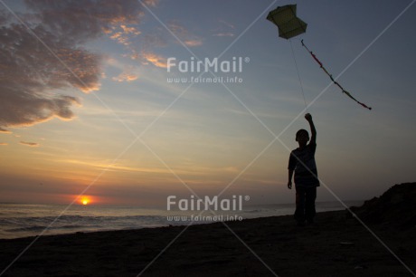 Fair Trade Photo 5 -10 years, Activity, Backlit, Beach, Colour image, Emotions, Evening, Freedom, Happiness, Kite, One boy, Outdoor, People, Peru, Playing, Sea, Silhouette, Sky, South America