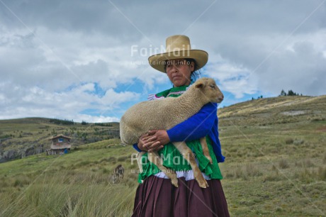 Fair Trade Photo Activity, Agriculture, Animals, Care, Clothing, Clouds, Day, Ethnic-folklore, Farmer, Grass, Horizontal, Latin, Looking at camera, One woman, Outdoor, People, Portrait fullbody, Rural, Sheep, Sky, Sombrero, Traditional clothing