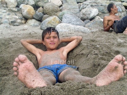 Fair Trade Photo Activity, Beach, Colour image, Day, Emotions, Happiness, Horizontal, Looking at camera, Low angle view, Lying, One boy, Outdoor, People, Peru, Portrait fullbody, Relaxing, Sand, Seasons, South America, Summer