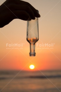 Fair Trade Photo Beach, Bottle, Colour image, Drop, Evening, Hand, Light, Ocean, Outdoor, Peru, Sea, Shooting style, Silhouette, South America, Sun, Sunset, Vertical, Water