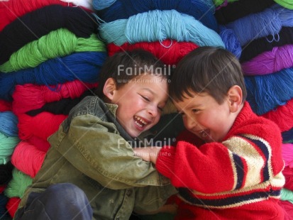 Fair Trade Photo 5-10 years, Activity, Casual clothing, Clothing, Colour image, Colourful, Cute, Day, Friendship, Horizontal, Indoor, Latin, Looking away, Market, People, Peru, Playing, Portrait halfbody, Sitting, Smiling, South America, Two boys