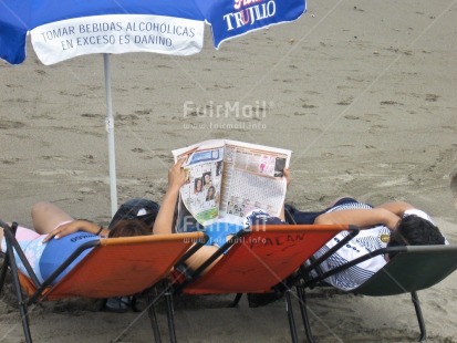 Fair Trade Photo Activity, Beach, Casual clothing, Clothing, Colour image, Day, Freedom, Friendship, Group of People, Horizontal, Lying, Outdoor, People, Peru, Reading, Relaxing, Sand, Seasons, South America, Summer, Umbrella