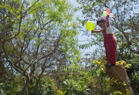 Fair Trade Photo 0-5 years, Activity, Balloon, Casual clothing, Clothing, Day, Emotions, Forest, Happiness, Horizontal, Jumping, Latin, One girl, Outdoor, People, Peru, South America, Tree