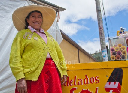 Fair Trade Photo Activity, Colour image, Day, Entrepreneurship, Food and alimentation, Horizontal, Ice cream, Latin, Looking at camera, Market, One woman, Outdoor, People, Peru, Portrait halfbody, Rural, Selling, Smiling, South America, Summer, Yellow
