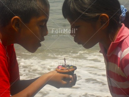 Fair Trade Photo Activity, Beach, Birthday, Blowing, Candle, Colour image, Cooperation, Day, Horizontal, Outdoor, People, Peru, Sea, South America, Together, Two children, Water