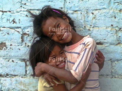 Fair Trade Photo 5-10 years, Activity, Colour image, Cute, Day, Emotions, Friendship, Fun, Happiness, Horizontal, Hug, Joy, Looking at camera, Love, Multi-coloured, Outdoor, People, Peru, Portrait halfbody, Smile, Smiling, South America, Street, Streetlife, Together, Two children, Two girls, Wall, Warmth