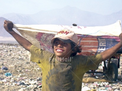 Fair Trade Photo 10-15 years, Activity, Animals, Casual clothing, Child labour, Clothing, Colour image, Day, Eating, Environment, Garbage, Garbage belt, Health, Horizontal, Hygiene, Looking away, One boy, Outdoor, People, Peru, Playing, Portrait halfbody, Recycle, Sanitation, Sitting, Smiling, South America
