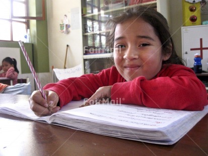 Fair Trade Photo Activity, Colour image, Day, Education, Exams, Good luck, Horizontal, Indoor, Looking at camera, One child, One girl, Pencil, People, Peru, Portrait halfbody, Portrait headshot, School, Smiling, Social issues, South America, Writing