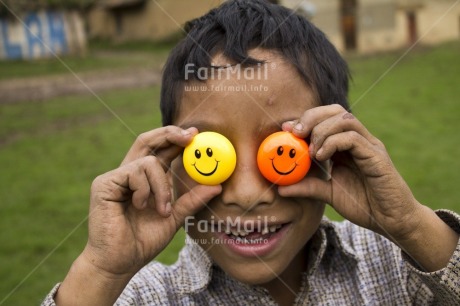 Fair Trade Photo 5-10 years, Activity, Colour image, Day, Emotions, Food and alimentation, Friendship, Fruits, Get well soon, Happiness, Horizontal, Latin, Looking away, One boy, Orange, Outdoor, People, Peru, Playing, Portrait headshot, Rural, Smile, Smiling, South America, Yellow