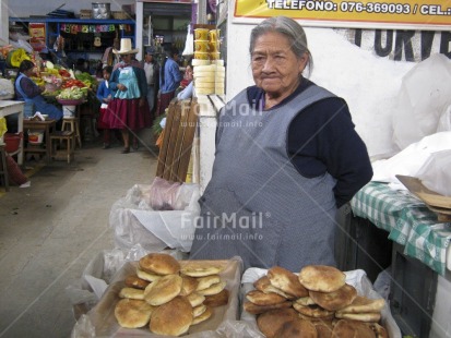 Fair Trade Photo Activity, Bread, Clothing, Colour image, Dailylife, Emancipation, Entrepreneurship, Food and alimentation, Horizontal, Looking away, Market, Multi-coloured, Old age, One woman, People, Peru, Portrait halfbody, Saleswoman, Selling, Sombrero, South America, Streetlife, Traditional clothing, Urban, Working