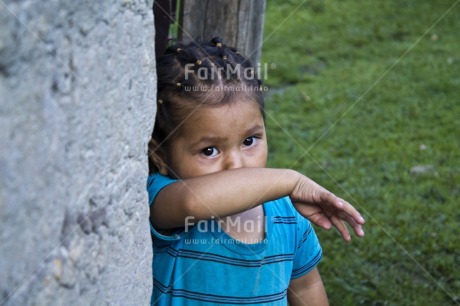 Fair Trade Photo 5-10 years, Activity, Blue, Casual clothing, Clothing, Colour image, Day, Grass, Horizontal, House, Latin, Looking at camera, One girl, Outdoor, People, Peru, Portrait halfbody, Rural, South America, Wall