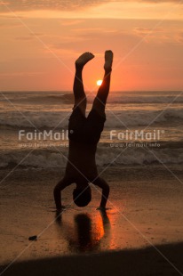 Fair Trade Photo Activity, Backlit, Beach, Colour image, Doing handstand, Evening, One boy, Outdoor, People, Peru, Reflection, Sea, Silhouette, South America, Spirituality, Sport, Sun, Sunset, Vertical, Yoga